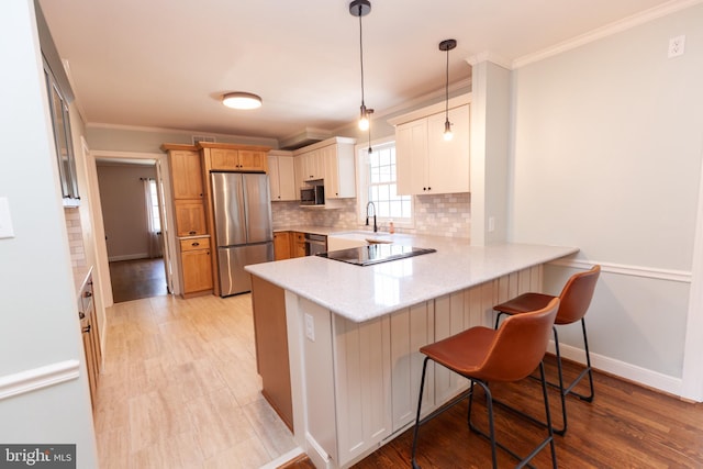204 W Irvin Ave W, Hagerstown, MD 21742 - kitchen with appliances with stainless steel finishes, a peninsula, backsplash, a breakfast bar area, and ornamental molding