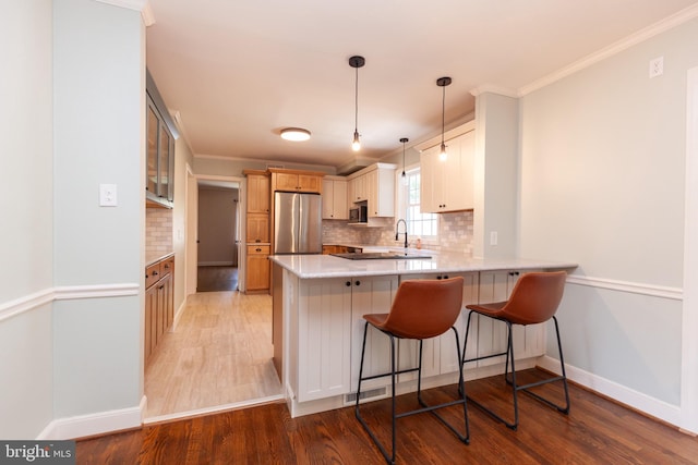 204 W Irvin Ave W, Hagerstown, MD 21742 - kitchen featuring stainless steel appliances, a peninsula, light wood-style flooring, backsplash, and ornamental molding