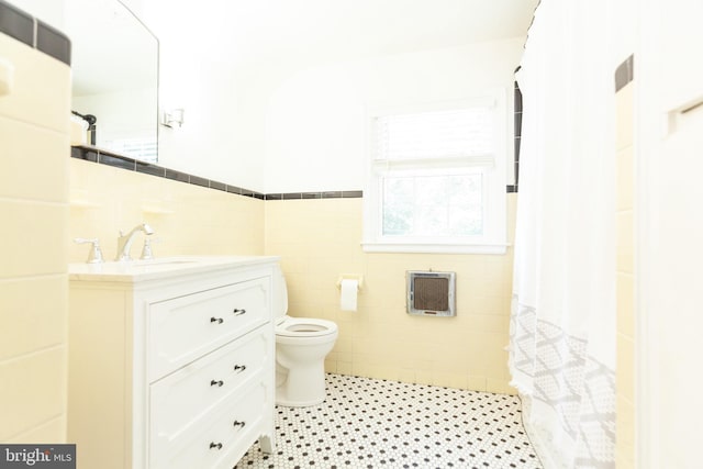 204 W Irvin Ave W, Hagerstown, MD 21742 - bathroom with tile walls, heating unit, vanity, a wainscoted wall, and a shower with shower curtain