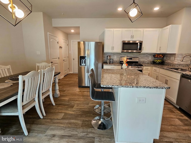 529 Birchwood Dr, Salisbury, MD 21804 - kitchen featuring stainless steel appliances, a sink, dark stone countertops, dark wood finished floors, and decorative backsplash