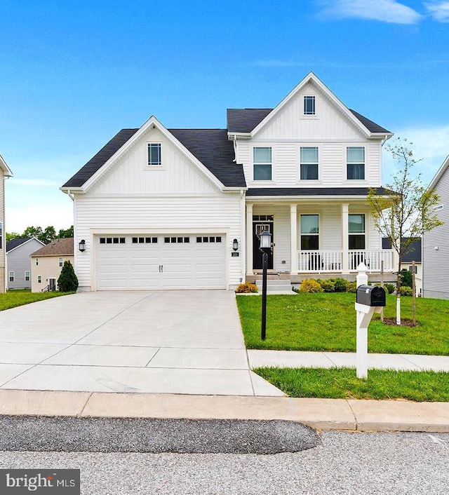 325 Hickory Ridge Cir, York, PA 17404 - view of front of house with board and batten siding, covered porch, concrete driveway, a front yard, and a garage
