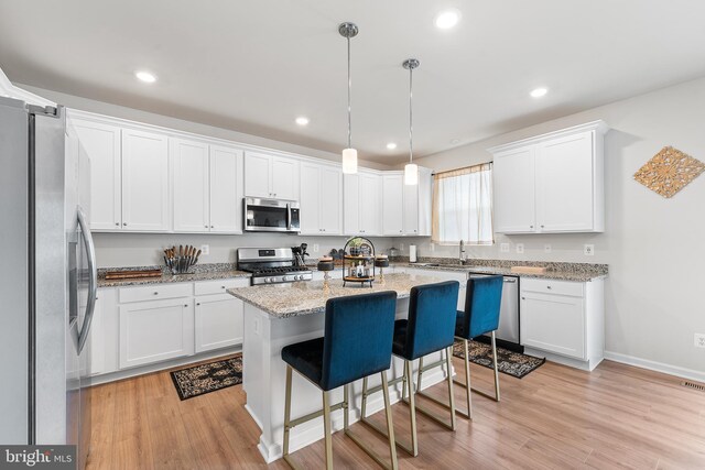325 Hickory Ridge Cir, York, PA 17404 - kitchen featuring appliances with stainless steel finishes, light wood-type flooring, white cabinetry, a center island, and recessed lighting