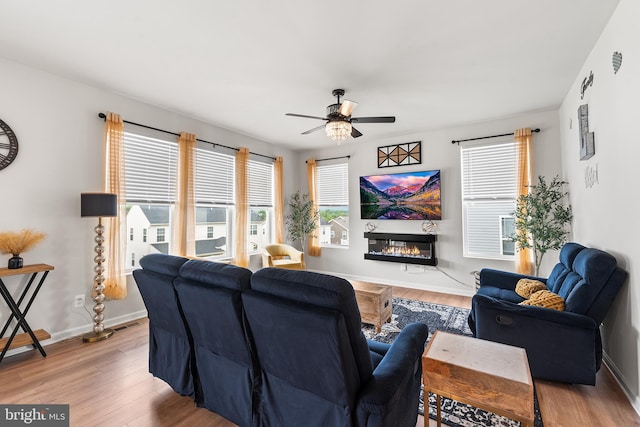 325 Hickory Ridge Cir, York, PA 17404 - living room featuring wood finished floors, a ceiling fan, a glass covered fireplace, and baseboards