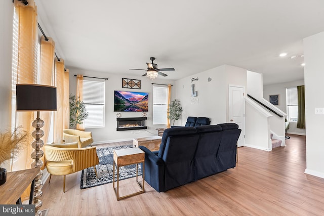 325 Hickory Ridge Cir, York, PA 17404 - living area with wood finished floors, stairs, a glass covered fireplace, ceiling fan, and recessed lighting