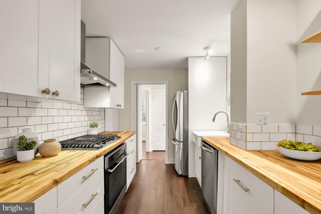 7307 15th Ave, Takoma Park, MD 20912 - kitchen with wood counters, appliances with stainless steel finishes, wall chimney range hood, dark wood finished floors, and backsplash