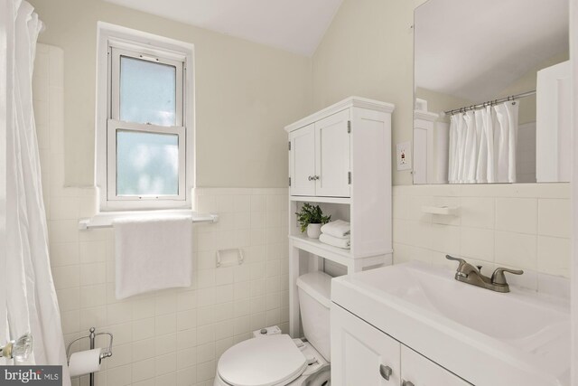 7307 15th Ave, Takoma Park, MD 20912 - bathroom featuring tile walls, vaulted ceiling, vanity, a wainscoted wall, and a shower with shower curtain