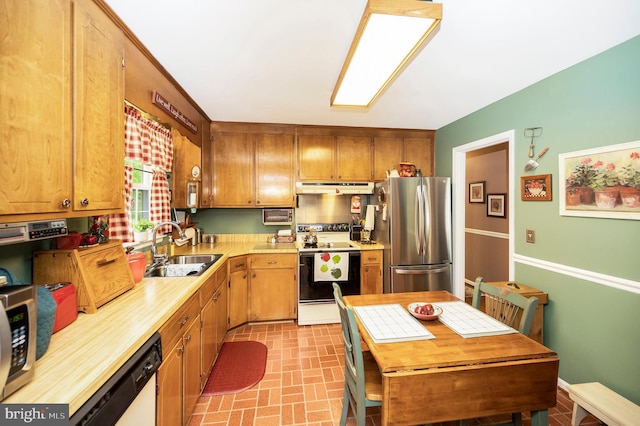 806 Edwards Dr, Fredericksburg, VA 22405 - kitchen with appliances with stainless steel finishes, a sink, under cabinet range hood, brick patterned flooring, and light countertops