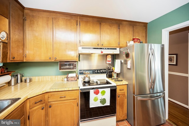 806 Edwards Dr, Fredericksburg, VA 22405 - kitchen with freestanding refrigerator, range with electric cooktop, under cabinet range hood, light countertops, and brown cabinets