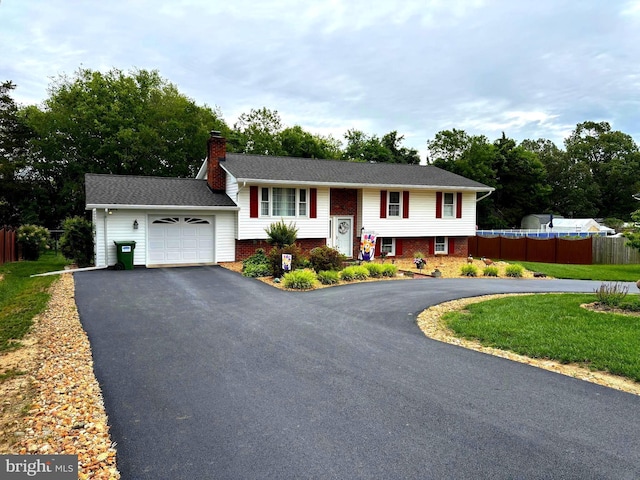 806 Edwards Dr, Fredericksburg, VA 22405 - raised ranch featuring asphalt driveway, a chimney, an attached garage, and brick siding