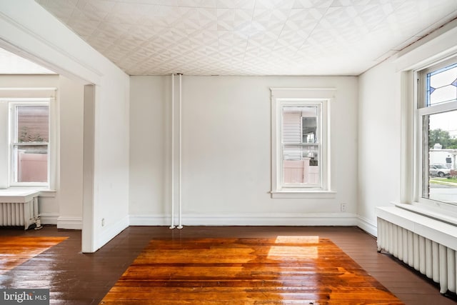 1926 W Broad St, Bethlehem, PA 18018 - empty room with radiator, wood-type flooring, an ornate ceiling, and baseboards