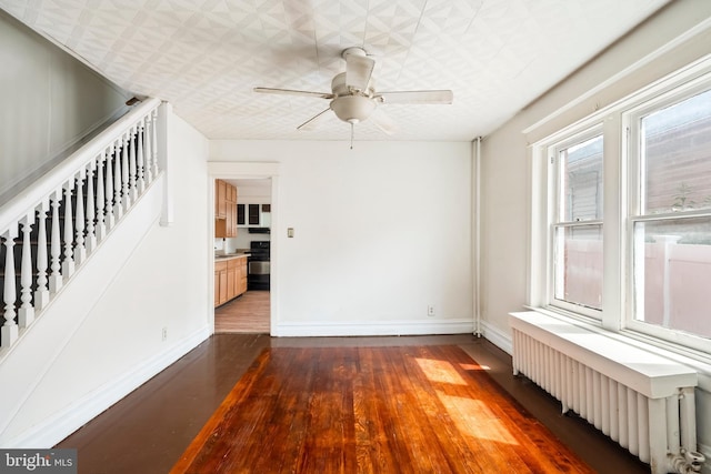 1926 W Broad St, Bethlehem, PA 18018 - spare room with radiator heating unit, stairway, wood finished floors, baseboards, and an ornate ceiling