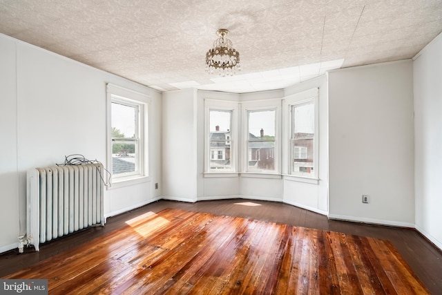1926 W Broad St, Bethlehem, PA 18018 - empty room featuring radiator heating unit, wood-type flooring, a chandelier, and baseboards