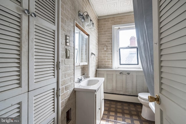 1926 W Broad St, Bethlehem, PA 18018 - half bath featuring baseboard heating, toilet, vanity, and brick wall