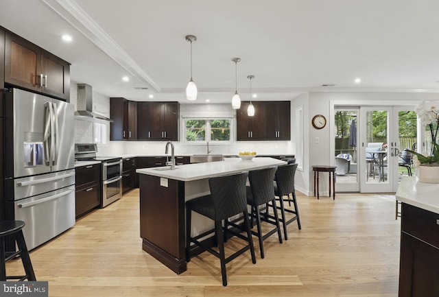 1367 Cedar Ave, Annapolis, MD 21403 - kitchen featuring stainless steel appliances, wall chimney range hood, light countertops, crown molding, and tasteful backsplash