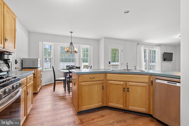 7 Pin Oak Dr, Dover, DE 19904 - kitchen featuring appliances with stainless steel finishes, a sink, a chandelier, light wood-style floors, and healthy amount of natural light
