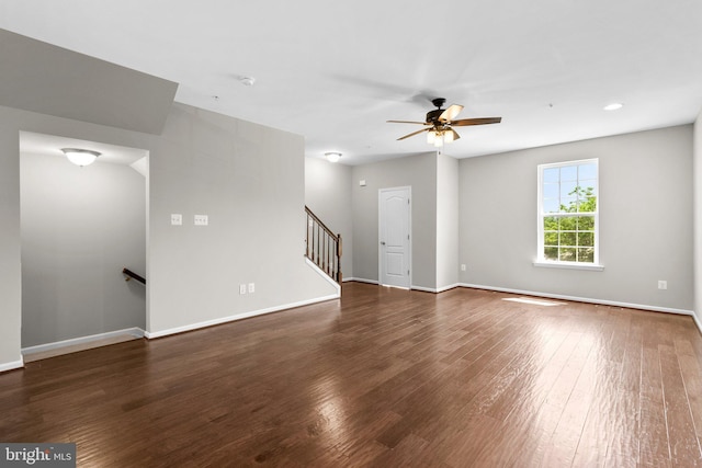 9778 Peace Springs Rdg, Laurel, MD 20723 - unfurnished living room with dark wood-style flooring, a ceiling fan, and stairway