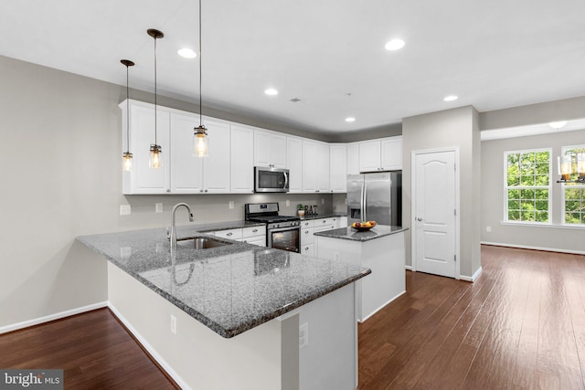 9778 Peace Springs Rdg, Laurel, MD 20723 - kitchen featuring stainless steel appliances, a kitchen island, a peninsula, dark wood-style floors, and dark stone counters