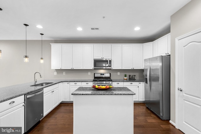 9778 Peace Springs Rdg, Laurel, MD 20723 - kitchen with appliances with stainless steel finishes, dark wood-style floors, white cabinets, recessed lighting, and decorative light fixtures
