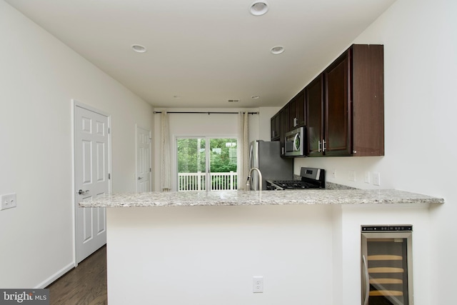 17023 Gibson Mill Rd, Dumfries, VA 22026 - kitchen featuring stainless steel appliances, wine cooler, a peninsula, dark brown cabinets, and dark wood-style flooring