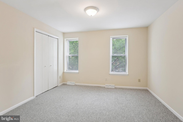 1018 W 7th St, Wilmington, DE 19805 - unfurnished bedroom featuring carpet flooring, multiple windows, and a closet