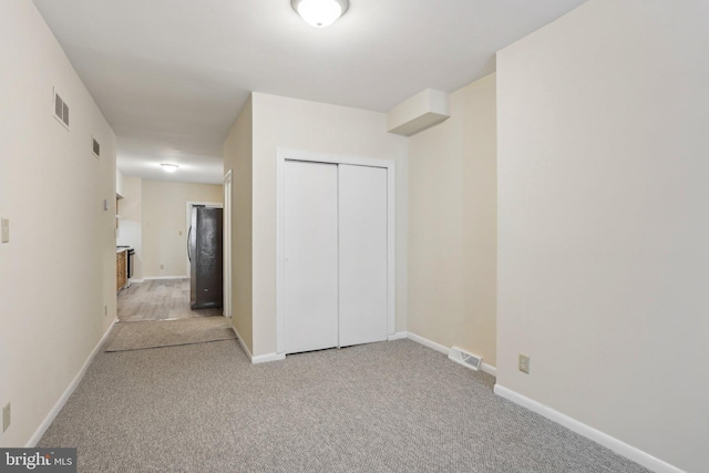 1018 W 7th St, Wilmington, DE 19805 - unfurnished bedroom with carpet, a closet, freestanding refrigerator, and baseboards