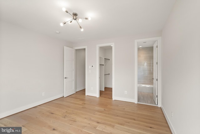 1554 Davidson Rd, Mclean, VA 22101 - unfurnished bedroom with a spacious closet, a chandelier, baseboards, and light wood finished floors