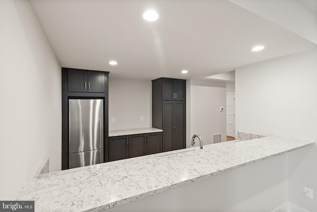 1554 Davidson Rd, Mclean, VA 22101 - kitchen featuring freestanding refrigerator, recessed lighting, a peninsula, light stone countertops, and a sink