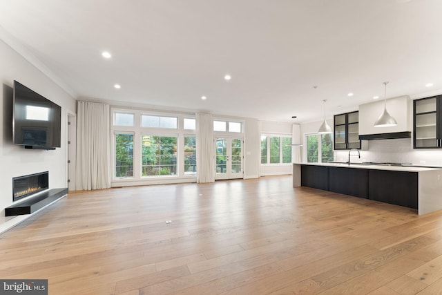 1554 Davidson Rd, Mclean, VA 22101 - kitchen with light countertops, open floor plan, a center island with sink, a glass covered fireplace, and recessed lighting