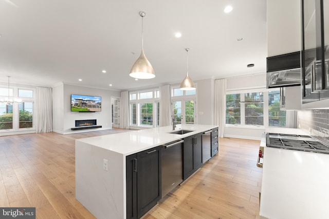 1554 Davidson Rd, Mclean, VA 22101 - kitchen with stainless steel appliances, dark cabinets, a lit fireplace, light countertops, and a kitchen island with sink