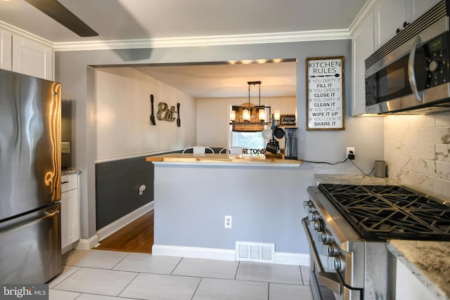 3018 Joshua Rd, Lafayette Hill, PA 19444 - kitchen with appliances with stainless steel finishes, white cabinets, ornamental molding, backsplash, and light tile patterned floors