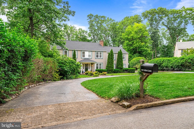 363 Colket Ln, Wayne, PA 19087 - colonial inspired home with asphalt driveway, a chimney, and a front lawn