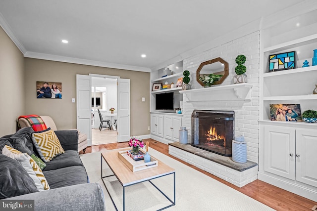 363 Colket Ln, Wayne, PA 19087 - living room with ornamental molding, built in shelves, light wood-style flooring, a fireplace, and recessed lighting