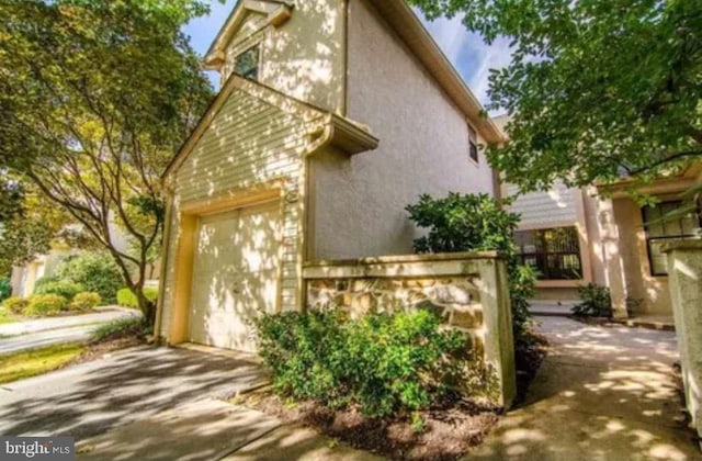 216 Mansion House Dr Unit 103D, West Chester, PA 19382 - view of front facade with driveway, stucco siding, and a garage