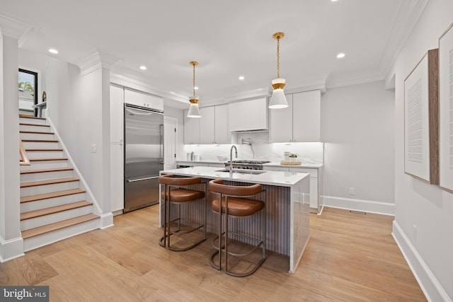 5376 28th St NW, Washington, DC 20015 - kitchen with built in refrigerator, light countertops, white cabinetry, tasteful backsplash, and a kitchen island with sink