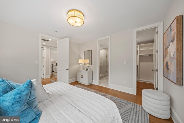 5376 28th St NW, Washington, DC 20015 - bedroom with wood finished floors, baseboards, and a walk in closet
