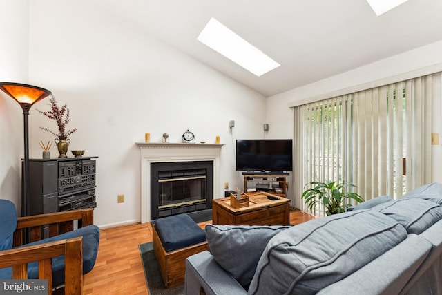4805 John St, Suitland, MD 20746 - living area featuring a skylight, light wood-style flooring, a glass covered fireplace, baseboards, and high vaulted ceiling