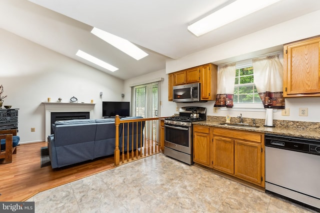 4805 John St, Suitland, MD 20746 - kitchen with stainless steel appliances, a sink, a skylight, lofted ceiling, and brown cabinets