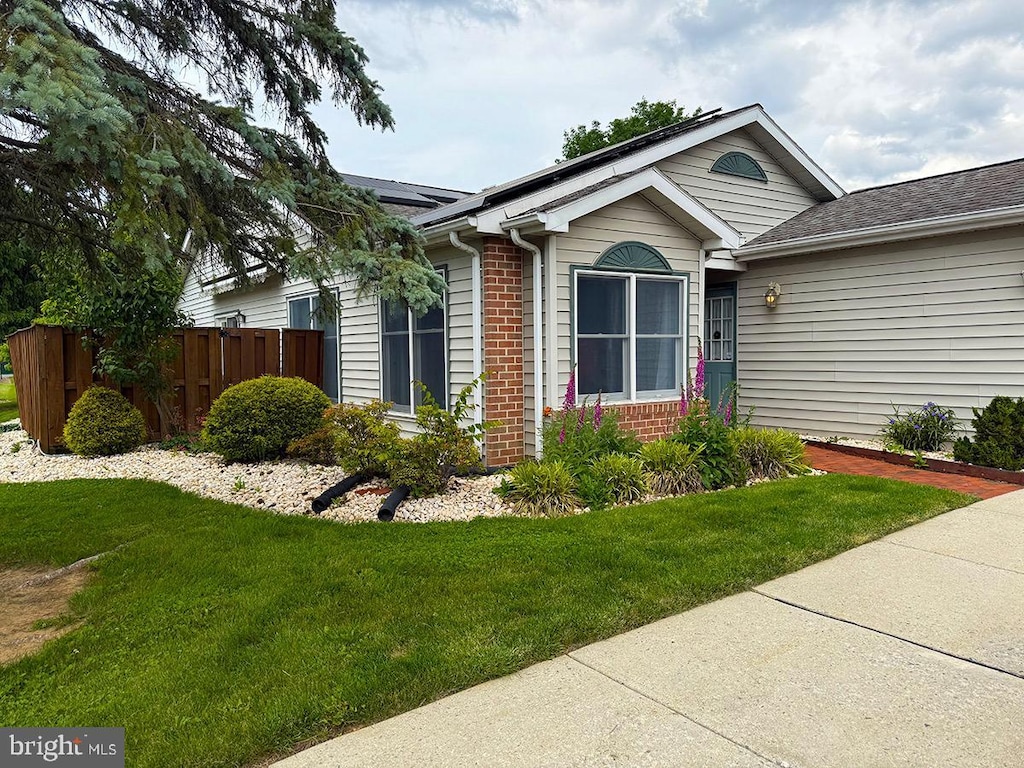 41 Abbey Ct, Carlisle, PA 17015 - view of front of home with brick siding, roof mounted solar panels, and roof with shingles