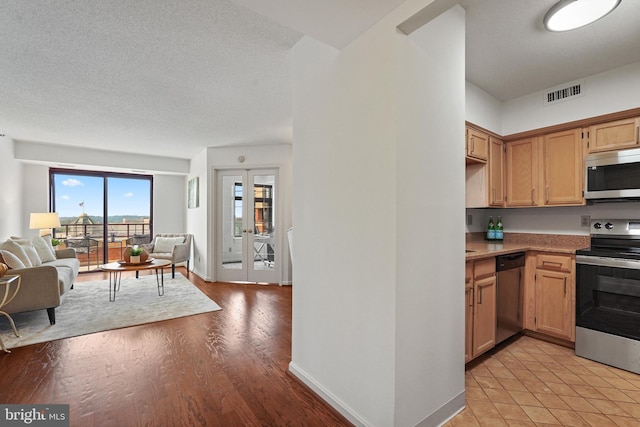 2400 Clarendon Blvd Unit 1015, Arlington, VA 22201 - kitchen with appliances with stainless steel finishes, open floor plan, light countertops, light wood-style floors, and a textured ceiling