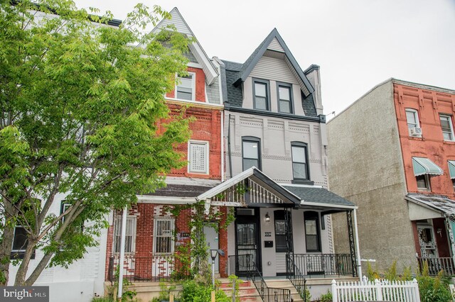 3137 Clifford St, Philadelphia, PA 19121 - view of property featuring brick siding, a porch, and a chimney