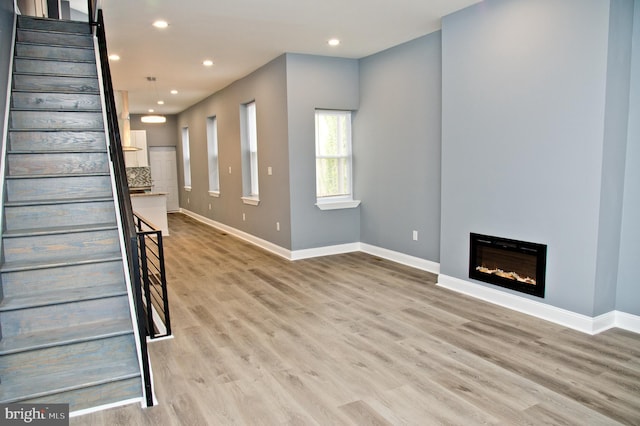3137 Clifford St, Philadelphia, PA 19121 - unfurnished living room featuring wood finished floors, recessed lighting, stairway, baseboards, and a glass covered fireplace
