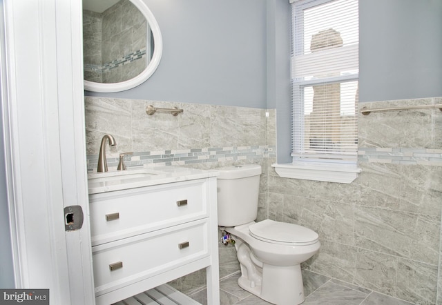 3137 Clifford St, Philadelphia, PA 19121 - bathroom featuring tile walls, toilet, vanity, and wainscoting