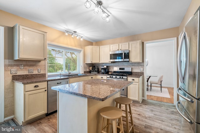 9341 Amaryllis Ave, Manassas, VA 20110 - kitchen with stainless steel appliances, light wood-style flooring, a breakfast bar, a sink, and decorative backsplash