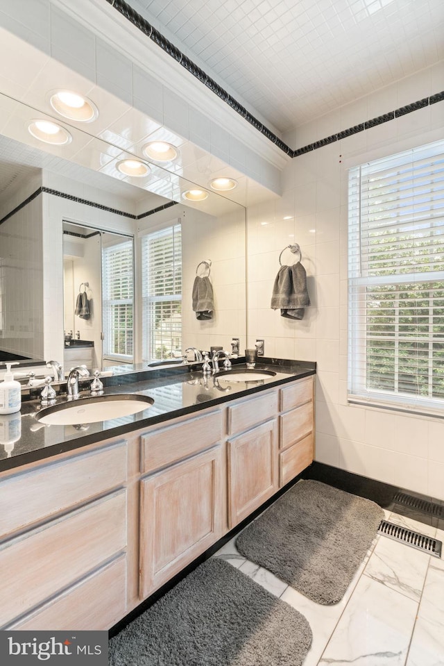9341 Amaryllis Ave, Manassas, VA 20110 - full bath featuring double vanity, healthy amount of natural light, marble finish floors, and recessed lighting