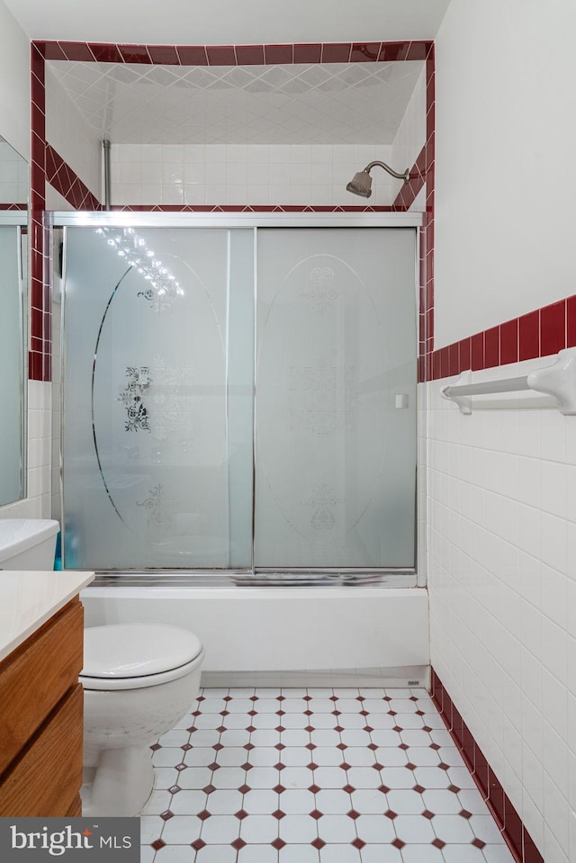 9341 Amaryllis Ave, Manassas, VA 20110 - full bath with tile walls, tile patterned floors, toilet, vanity, and shower / bath combination with glass door