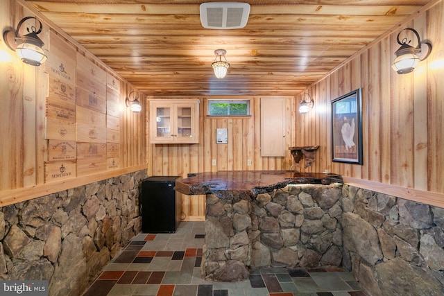 9341 Amaryllis Ave, Manassas, VA 20110 - miscellaneous room with wooden ceiling, wood walls, bar, and stone finish flooring