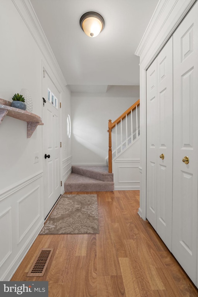9341 Amaryllis Ave, Manassas, VA 20110 - entrance foyer with stairway, light wood finished floors, ornamental molding, and a wainscoted wall