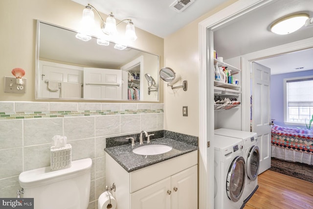 706 6th St SW, Washington, DC 20024 - bathroom with independent washer and dryer, vanity, toilet, wood finished floors, and connected bathroom