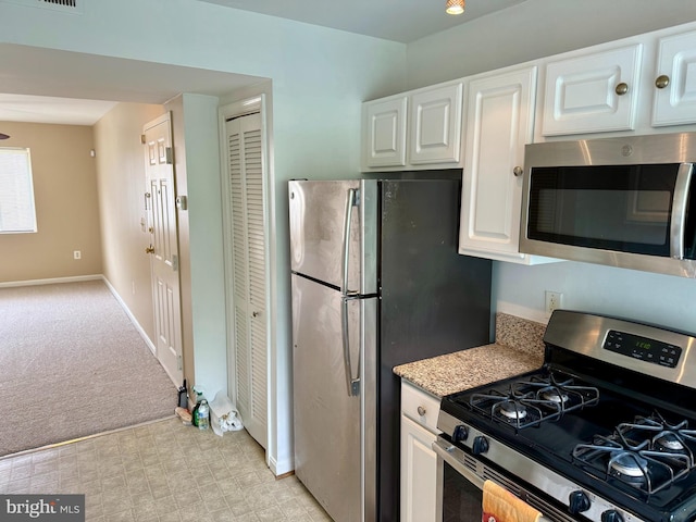 4212 Benning Rd NE Unit 6, Washington, DC 20019 - kitchen with appliances with stainless steel finishes, white cabinets, light countertops, light colored carpet, and baseboards