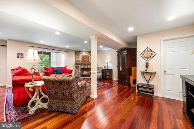 41 Musket Ct, West Chester, PA 19382 - living room with a stone fireplace, dark wood finished floors, baseboards, ornate columns, and recessed lighting
